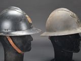 pair of firemen ' s helmets on mannequin heads against a gray background