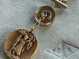an image of a close up of a gold medal on a chain