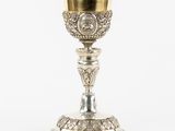 une image représentant une coupe en argent bordée d'or, posée sur une table