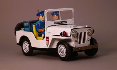 a toy jeep with a policeman in the back of it