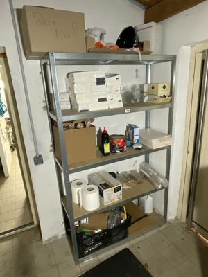 une pièce dans laquelle se trouvent un réfrigérateur, des étagères et d'autres objets