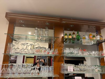 de nombreux verres et bouteilles sur les étagères de la pièce