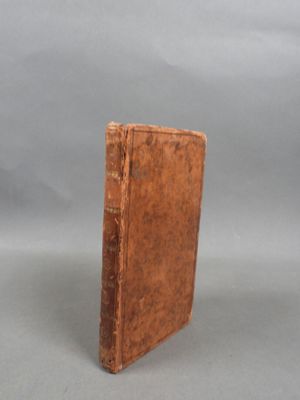 an old book sitting on top of a table on a gray surface