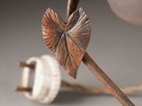 a close up of a metal object with a leaf on it