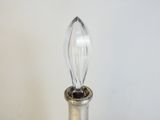 une bouteille en argent avec un bouchon en verre posée sur une table