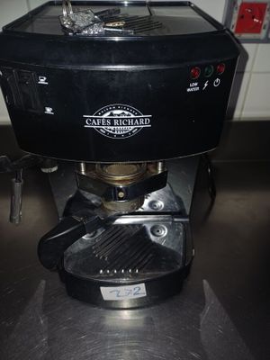 une cafetière noire posée sur le plan de travail d'une cuisine