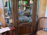 un vaisselier en bois avec une porte vitrée et une chaise