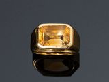 une bague en or sertie d'une citrine sur un fond noir