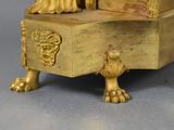 a gold clock with a lion on top of it