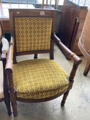 une chaise qui se trouve dans une pièce, près d'une fenêtre
