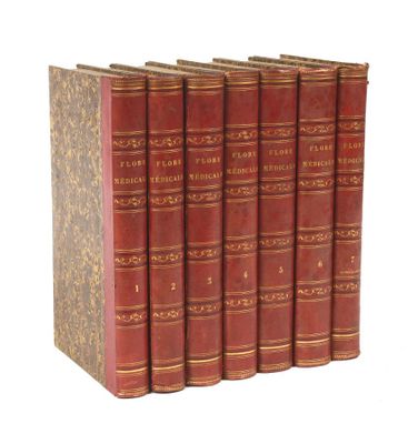six livres rouges sont alignés sur une surface blanche