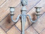 two candles that are on the wall on the wooden floor