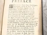 un livre ouvert posé sur une table sur laquelle se trouve une horloge
