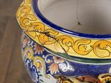 a blue and yellow vase sitting on a wooden table