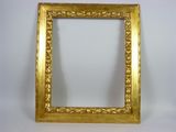 an antique gold frame on a white wall with a white background