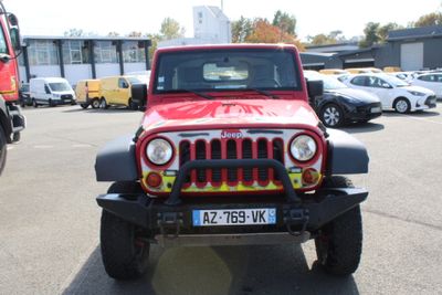 a red and black jeep parked in a parking lot