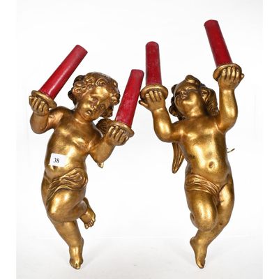 pair of antique brass cherensils with red candles on them