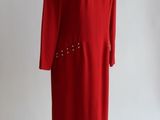 une robe rouge sur un mannequin, posée sur un fond blanc