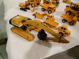 tout un tas de petits engins de chantier en plastique posés sur une table