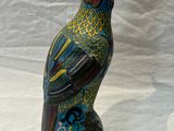 un oiseau aux couleurs vives perché sur un vase