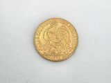 a close up of a gold coin on a white surface
