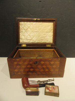 a small wooden box with a handle and a cigarette in it