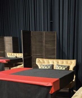 beaucoup de tables et de chaises recouvertes d'une nappe rouge et noire