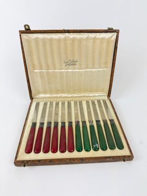 six knives in a wooden case on a white surface