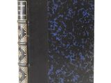 an old black book with a blue cover and gold trim