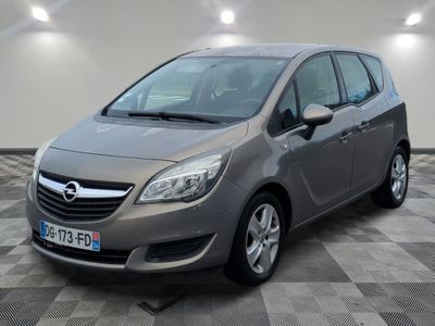 L'Opel grise est garée dans une grande pièce au sol carrelé.