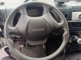 a steering wheel and dashboard of a vehicle in a parking lot