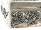 a silver box that has a dragon on it