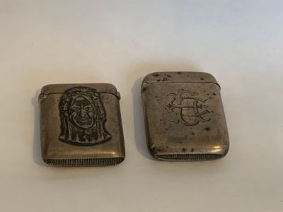 deux briquets en argent sur lesquels figurent l'image d'un homme et d'une femme