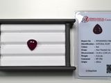 un gros plan sur un diamant rouge en forme de cœur dans un écrin