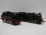 un train noir et rouge posé sur une surface blanche