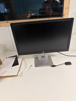 l'écran est posé sur le bureau, à côté du clavier
