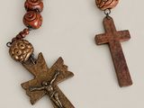 a close up of a cross and a rosary on a table