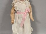 a small doll with a pink bow on it ' s head