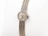 a close up of a wrist watch on a white pillow