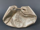 the gold purse is sitting on top of a gray surface