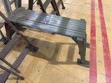 a wooden bench sitting on the floor next to some chairs
