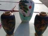 trois vases posés sur une table à l'extérieur par une journée ensoleillée