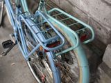 a blue bicycle parked next to a brick wall