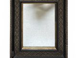 a close up of a black and gold picture frame on a white background