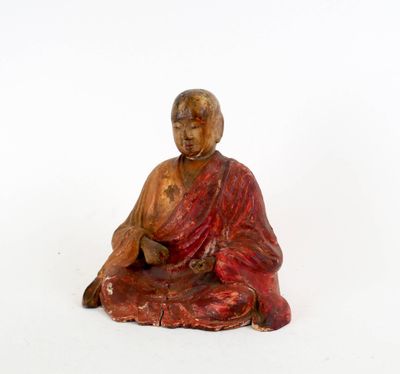 statue représentant une personne assise en position de méditation sur une surface blanche