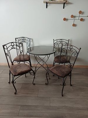 une table en verre et quatre chaises dans une pièce