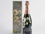 une bouteille de champagne à côté d'un bouquet de fleurs