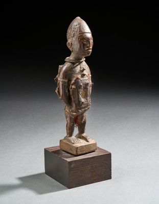 une image représentant une statue en bronze d'un homme debout sur un socle en bois