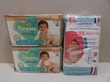 trois boîtes de couches pour bébé posées sur une table