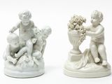 two figurines of a boy and a girl sitting on a rock